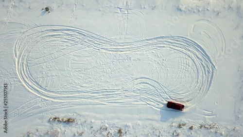 The old red car is drifting in the winter on the set and draws the symbol of the eight photo