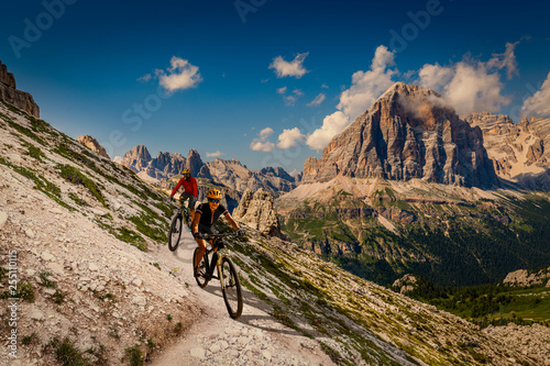 Single mountain bike rider on electric bike, e-mountainbike rides up mountain trail. Man riding on bike in Dolomites mountains landscape. Cycling e-mtb enduro trail track. Outdoor sport activity. © Gorilla