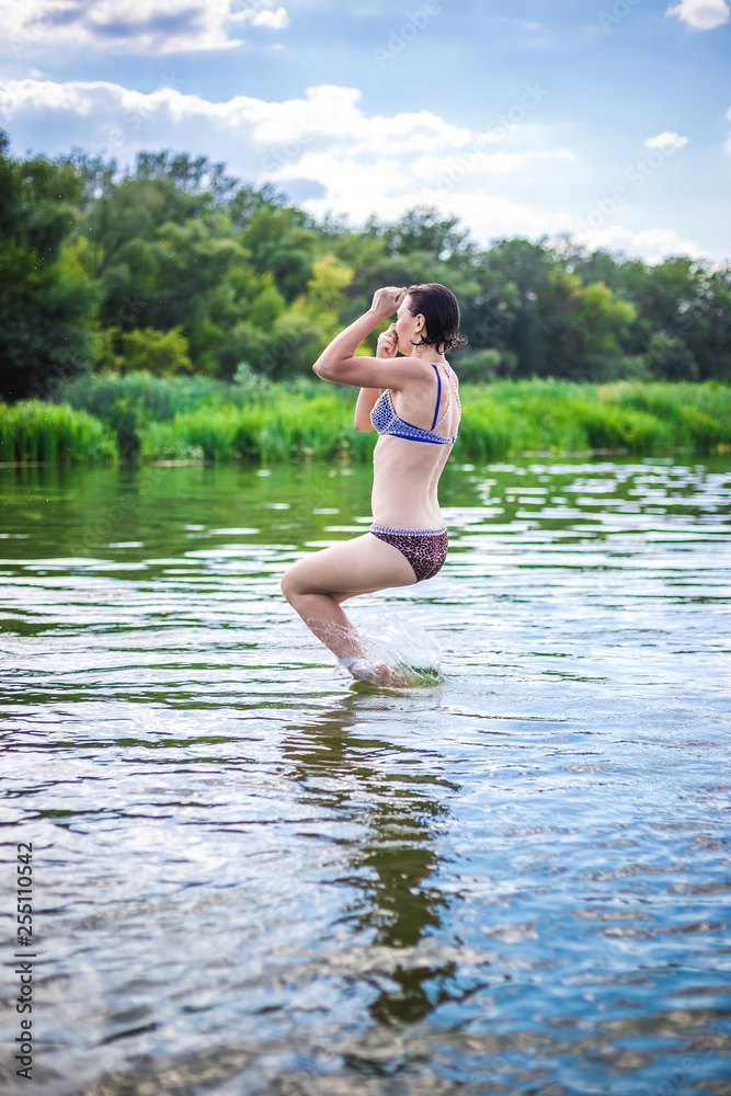 A beautiful woman jumping into the water from a pier. A beautiful woman jumping into the water from a pier.