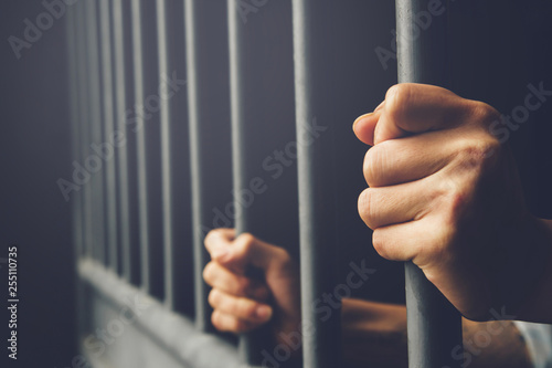 Fotobehang Man in prison hands of behind hold Steel cage jail bars