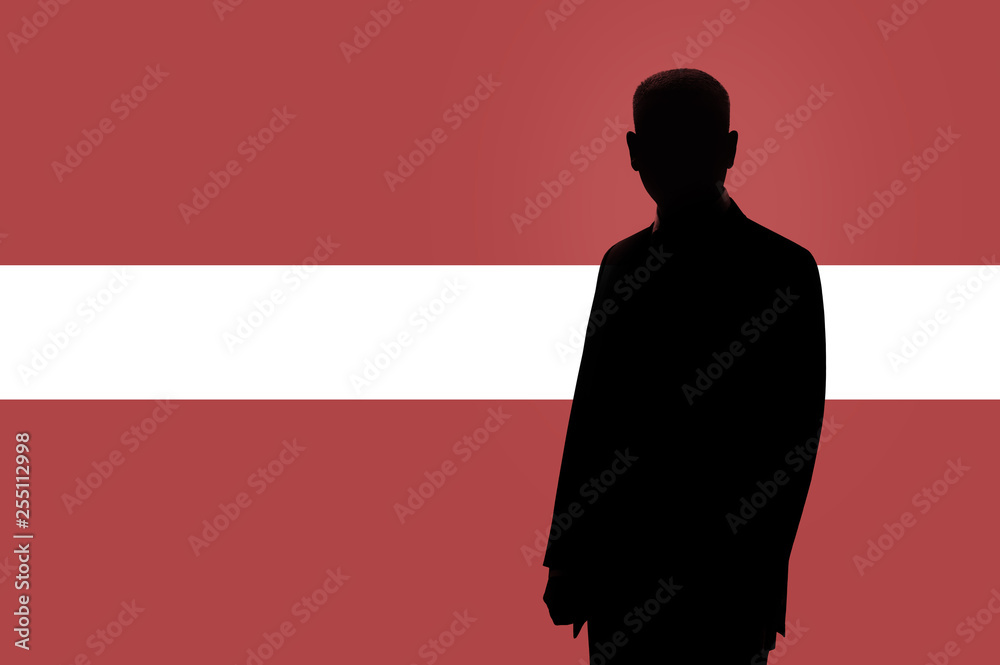 Silhouette of businessman on the background of the Latvian flag. Silhouette of a man, with space for text. Silhouette of businessman on the background of the Latvian flag. Silhouette of a man, with space for text.