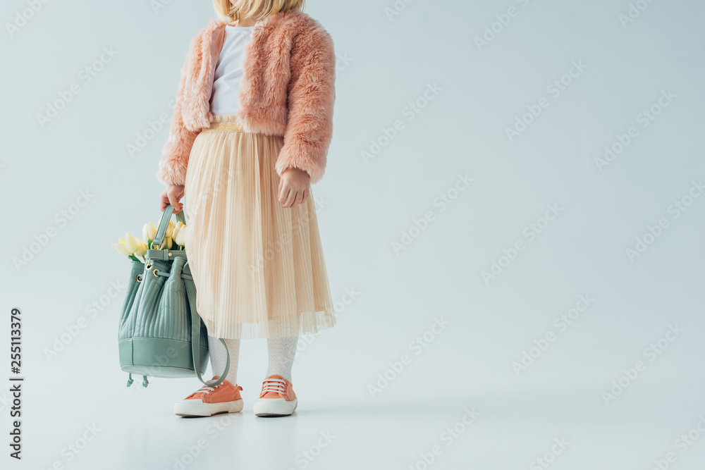 cropped view of cute kid holding bag with white tulips on grey background - obrazy, fototapety, plakaty 