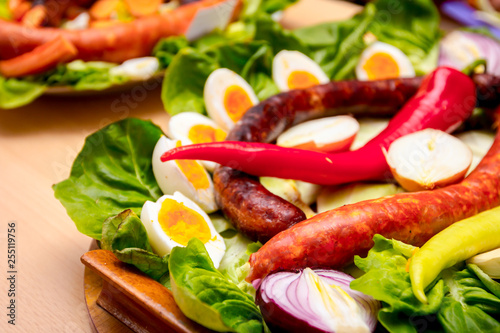 Traditional sausages are decorated with fresh green chili peppers and chopped boiled eggs