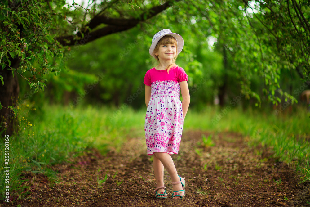 Happy little girl in bright dress walk in garden Happy little girl in bright dress walk in garden