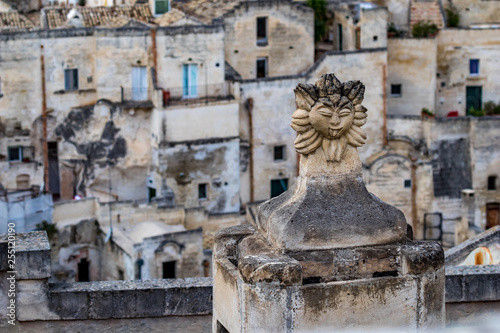 Summer day high-angle scenery street view of an artistic chimney decoration over the amazing ancient town of the Sassi with blurred background of pattern of buildings in Matera, Basilicata, Italy