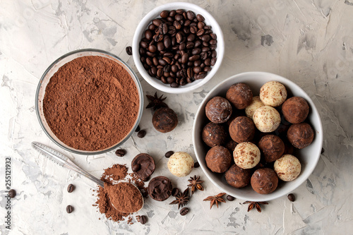assorted chocolates. Candy balls of different types of chocolate on a light concrete background. cocoa, star anise and coffee beans. top view