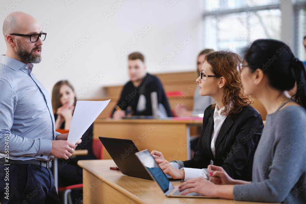Lecturer and multinational group of students in an auditorium Lecturer and multinational group of students in an auditorium