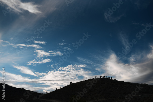 blue sky with clouds hill mountains with contours of people