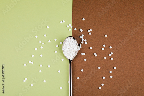 Bild auf Leinwand Sugar-replacing tablets with a spoon on a green-brown background