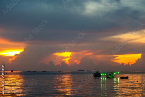 colorful flame cloud sunset fisging boat on sea and sky photo