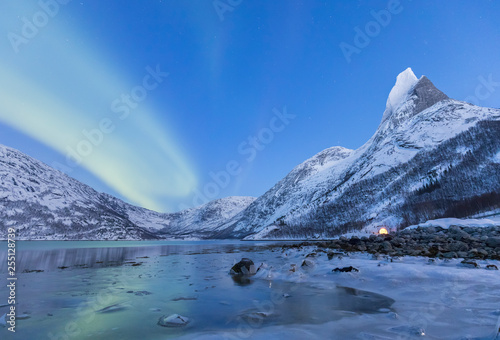 Northern lights over frozen sea in a Tysfjord bay and near the Norway's national mountains granitic snowy peak called Stetind,tysfjord Nordland county Norway Europe photo