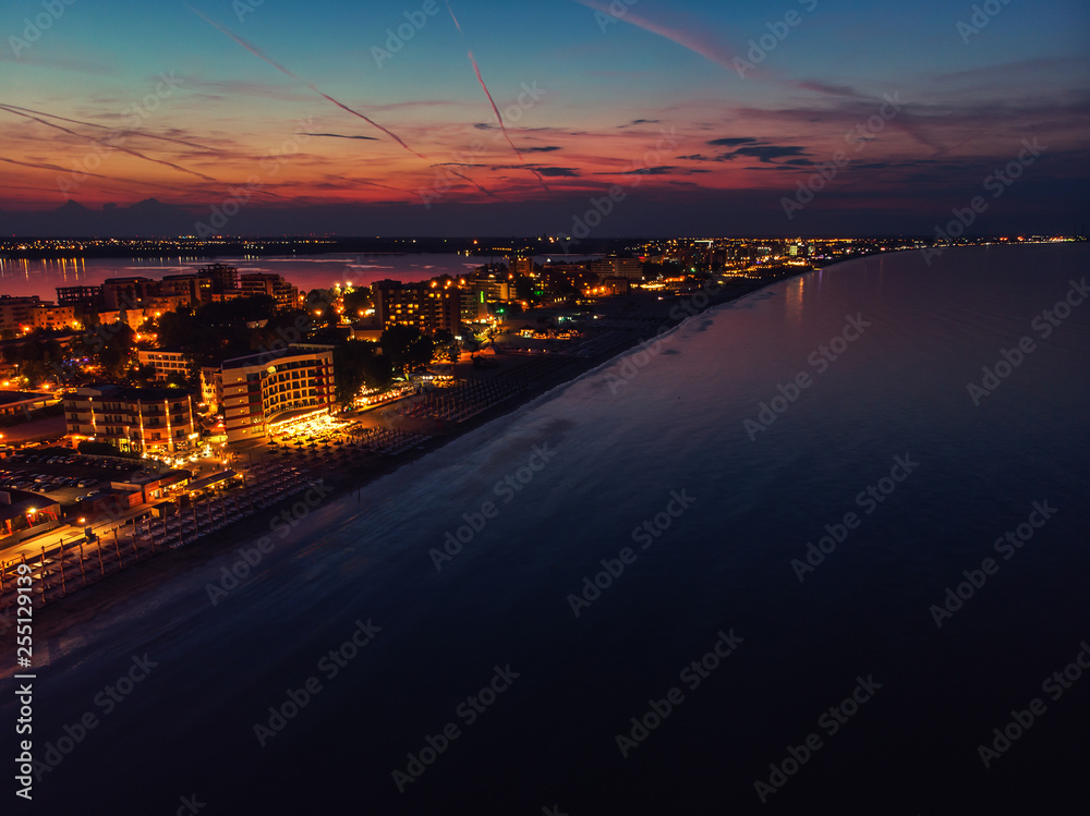Drone bird's eye view photo of famous resort of Mamaia as seen at night with dazzling lights and waves