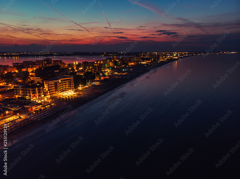 Fototapeta premium Drone bird's eye view photo of famous resort of Mamaia as seen at night with dazzling lights and waves