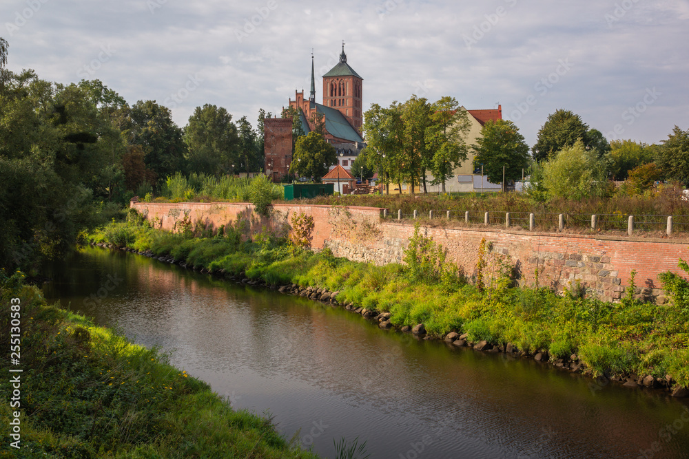 Fototapeta Basilica of St. Catherine and Pasleka river in Braniewo, Warminsko-Mazurskie, Poland