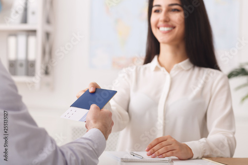Travel agent giving tickets and passport to tourist