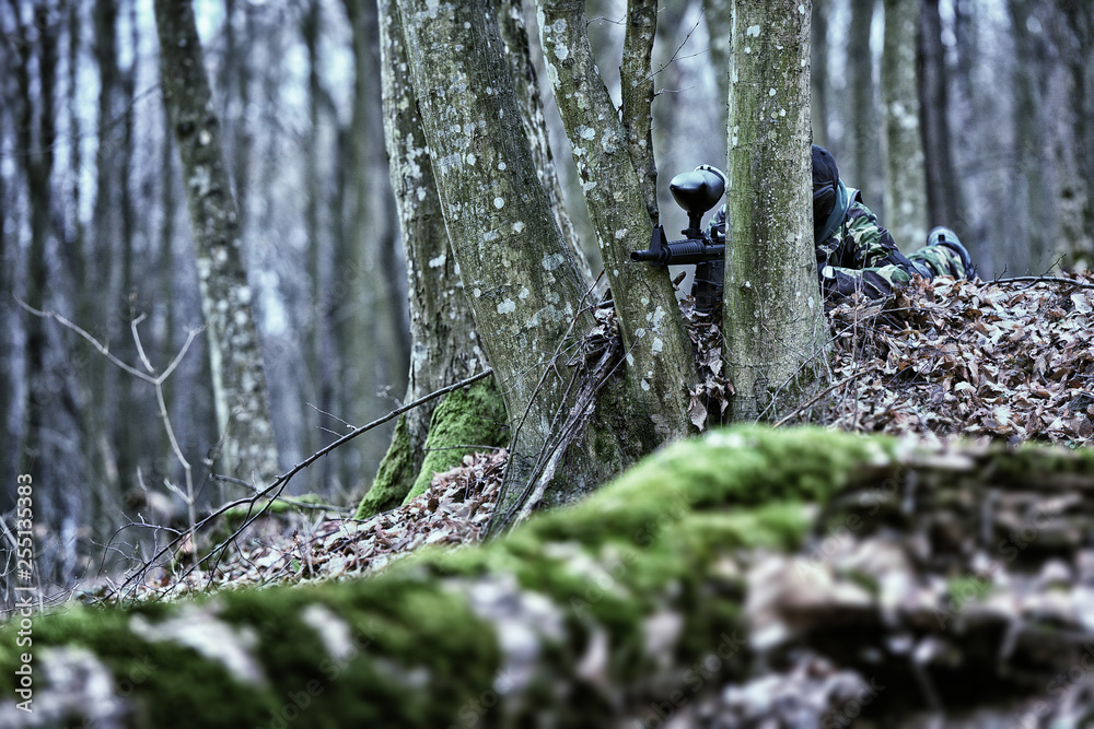 Player in a protective mask play paintball ambush position Player in a protective mask play paintball ambush position