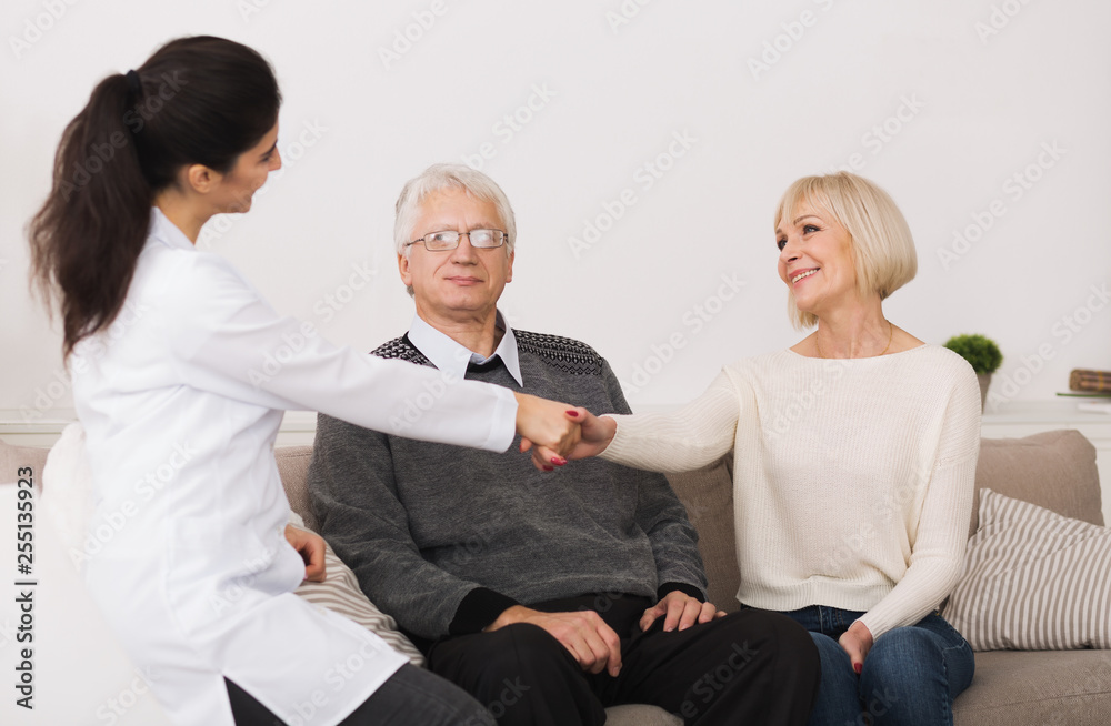 Senior couple welcoming doctor during home visit Senior couple welcoming doctor during home visit