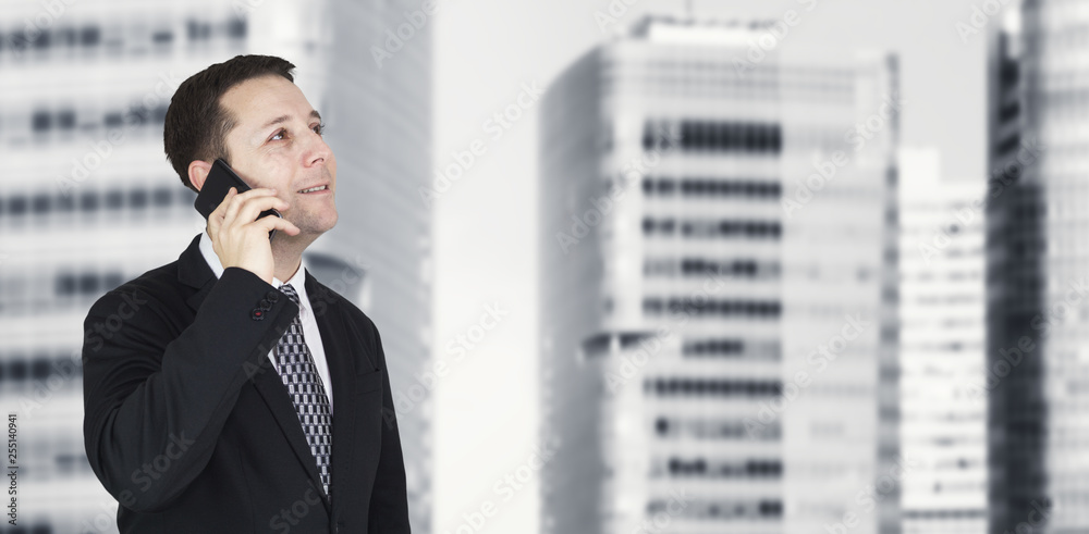 Businessman Talking On The Phone With Business City and Corporate Buildings In Background