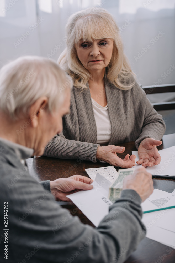 Obraz premium senior couple having discussion while sitting at table with paperwork