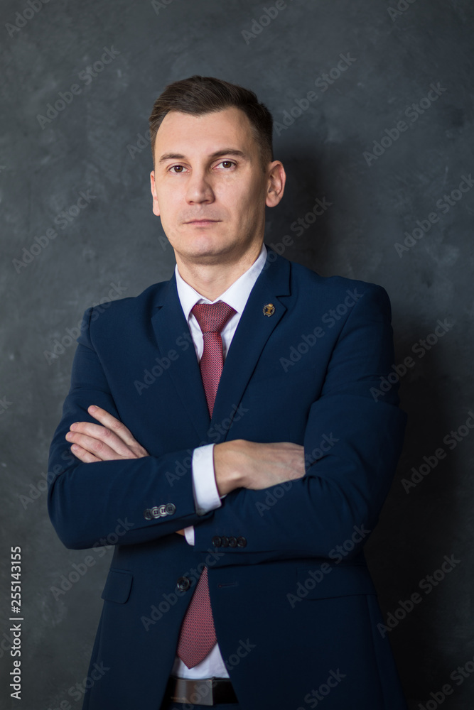 Portrait of young intelligent man lawyer standing with crossed arms in modern office building interior, successful male bank employee dressed in luxury suit posing with copy space area for your text Portrait of young intelligent man lawyer standing with crossed arms in modern office building interior, successful male bank employee dressed in luxury suit posing with copy space area for your text