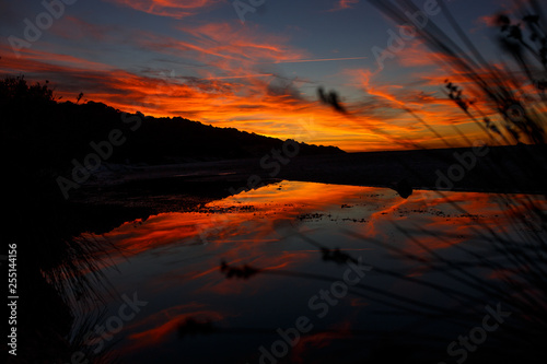 Beautiful red sunset landscape at sunset and island sky. Amazing summer sunset view on the beach.