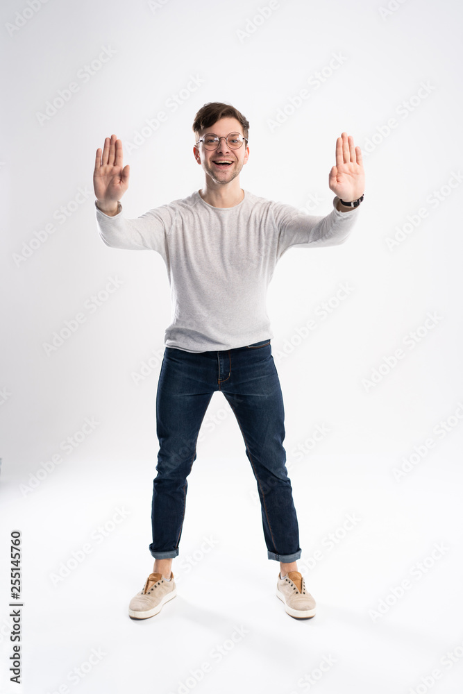Handsome man wearing glasses amazed and smiling to the camera while presenting with hand isolated on white. Handsome man wearing glasses amazed and smiling to the camera while presenting with hand isolated on white.