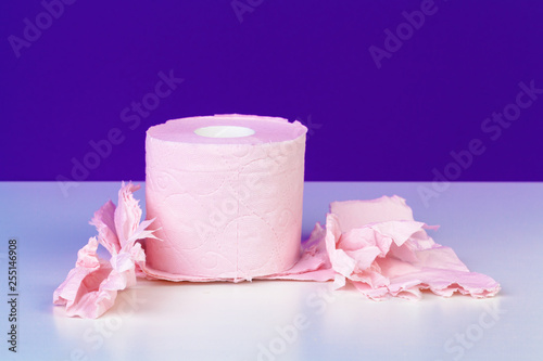 Toilet paper rolls isolated on white table with purple background