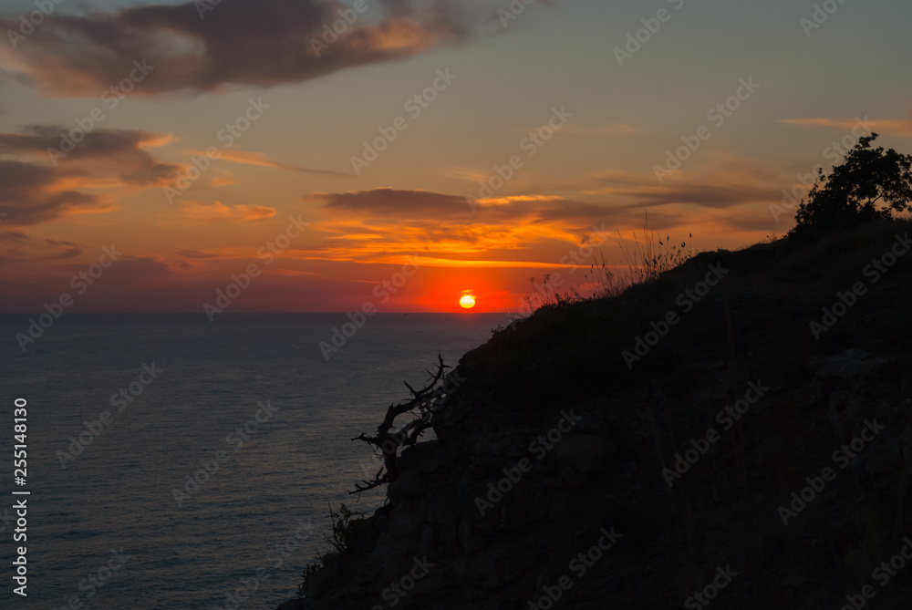 A beautiful seascape with sunset and burning clouds and calm sea