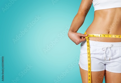 Картината върху платно Slim young woman measuring her thin waist