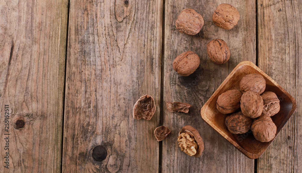 walnuts on a rustic wooden table - close up - walnuts broken up and closed walnuts on a rustic wooden table - close up - walnuts broken up and closed