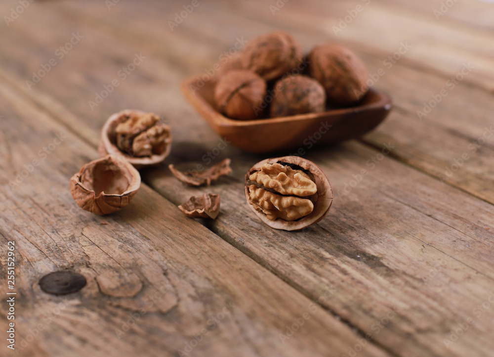 walnuts on a rustic wooden table - close up - walnuts broken up and closed walnuts on a rustic wooden table - close up - walnuts broken up and closed