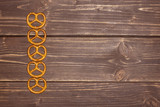 Group of five whole mini salted pretzels flatlay on brown wood