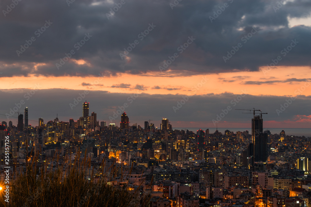 This is a capture of the sunset in Beirut capital of Lebanon with a warm orange color, and you can see Beirut downtown in the foreground with some beautiful cloud in the background