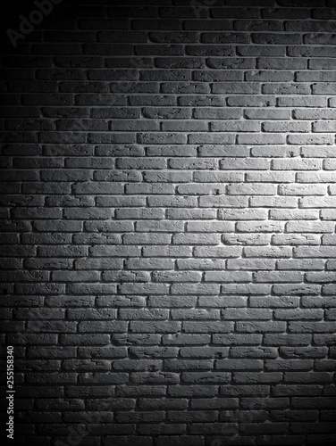 Background of black and white brick textured vintage wall with light pattern