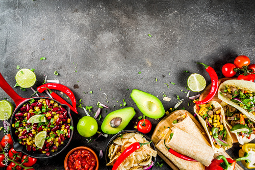 Cinco de Mayo food.Mexican food concept background with taco, quesadilla, burrito, chili, salsa sauce, hot pepper, lime. Black concrete background top view copy space