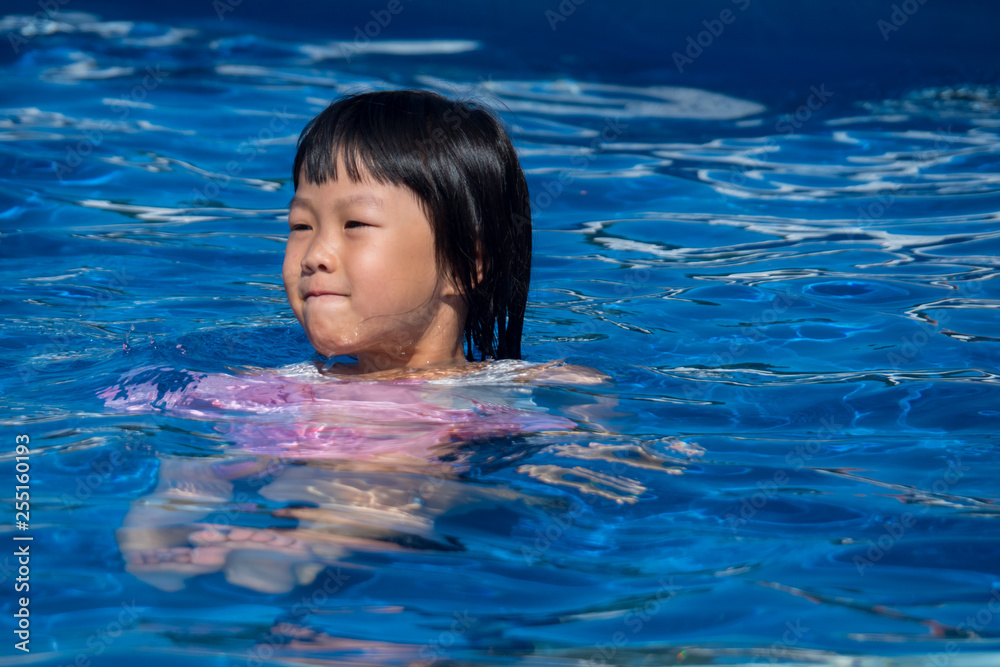 真夏のプールで遊んでいる子供