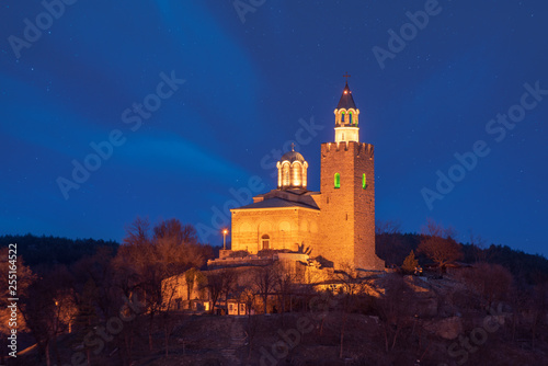 Beautiful view of illuminated medieval Tsarevets fortress in Veliko Tarnovo, Bulgaria at night. the famous historical capital. Panorama. Patriarch Church on the Tsarevets hill with lights