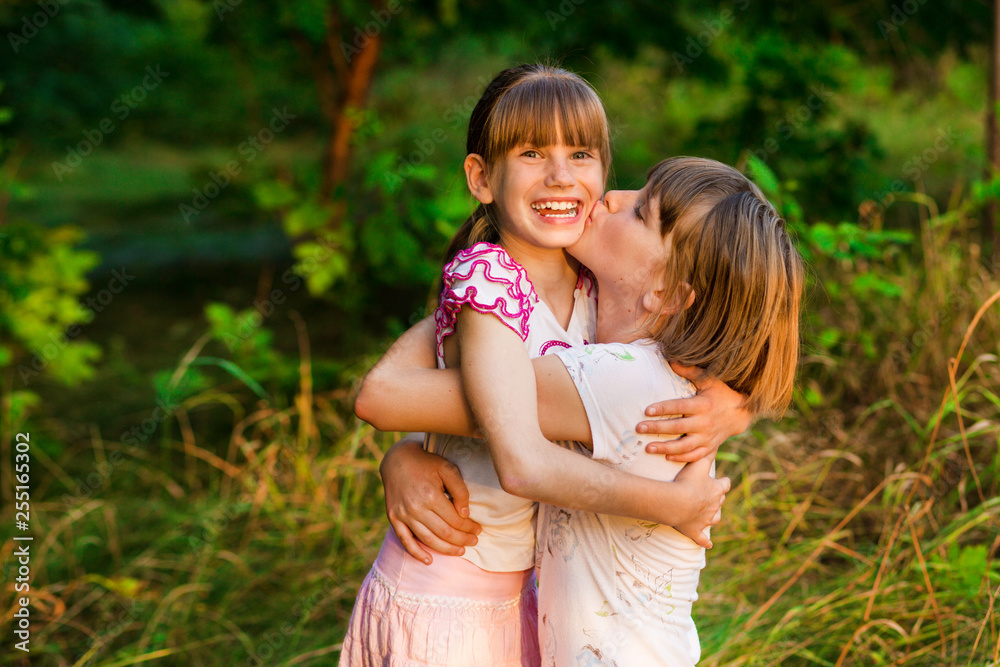 Little girl is very happy that she has sister. Loving sister hugging cute little girl showing love care support. Sincere warm relationships. Concept of happy family, adoption, foster sister. Little girl is very happy that she has sister. Loving sister hugging cute little girl showing love care support. Sincere warm relationships. Concept of happy family, adoption, foster sister.