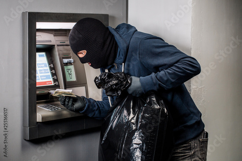 Thief. Hacker stealing money from ATM machine. Phishing, ATM skimming