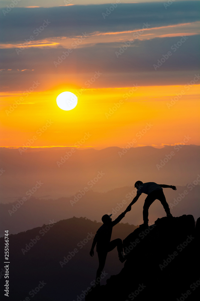 Teamwork friendship hiking help each other trust assistance silhouette in mountains, sunrise. Teamwork of two men hiker helping each other on top of mountain climbing team beautiful sunrise landscape Teamwork friendship hiking help each other trust assistance silhouette in mountains, sunrise. Teamwork of two men hiker helping each other on top of mountain climbing team beautiful sunrise landscape