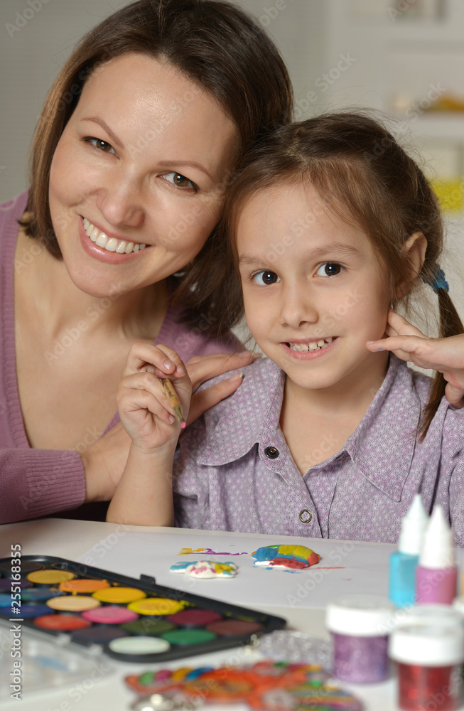 Portrait of mother and little girl painting at home Portrait of mother and little girl painting at home