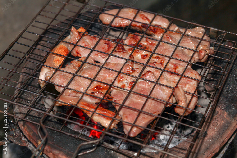 Charcoal-boiled pork neck grill on old stove at thailand