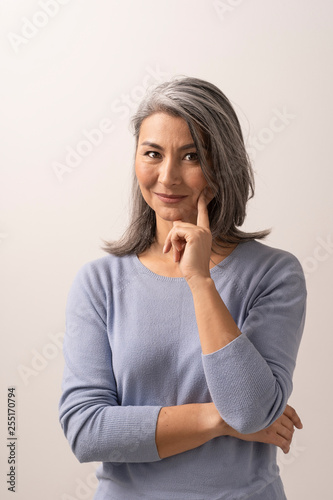 Fotografie Asian woman smiling and pointing her finger to her cheek
