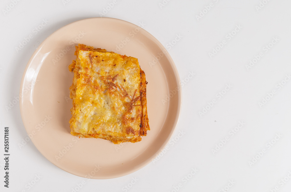 A piece of lasagna on a plate on the table.