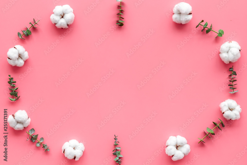 Flowers frame with fresh eucalyptus branches and cotton on pink background top view copy space Flowers frame with fresh eucalyptus branches and cotton on pink background top view copy space