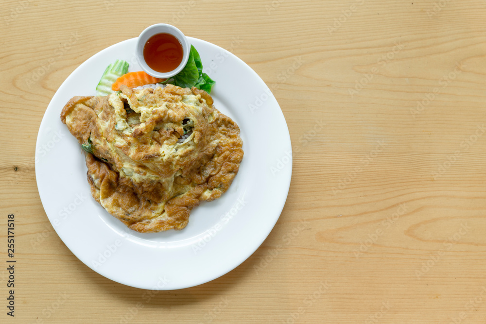 Thai Omelet with jusmine steamed rice on wood table background