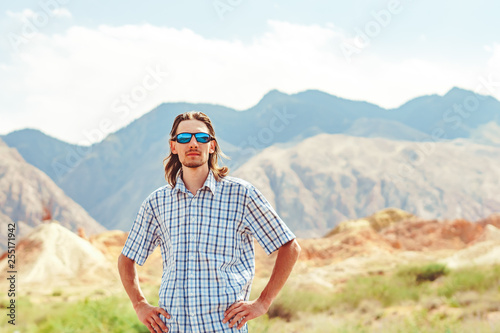 the guy standing on a background of mountains