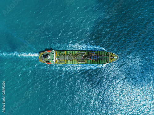 Aerial top view Oil ship tanker full speed and beautiful wave pattern on the sea for transportation oil from refinery. © Pawinee