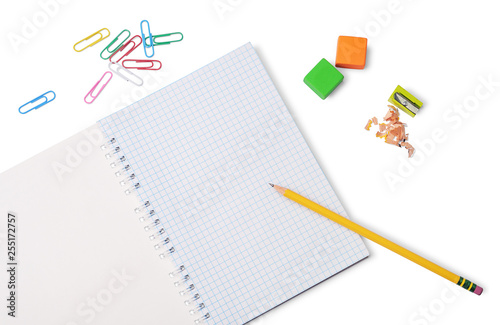 Yellow pencil, grid notepad, colored erasers, pencil sharpener and paper clips isolated on white background. School or office stationery.