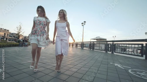 Beautiful girls go and dance at sunset.